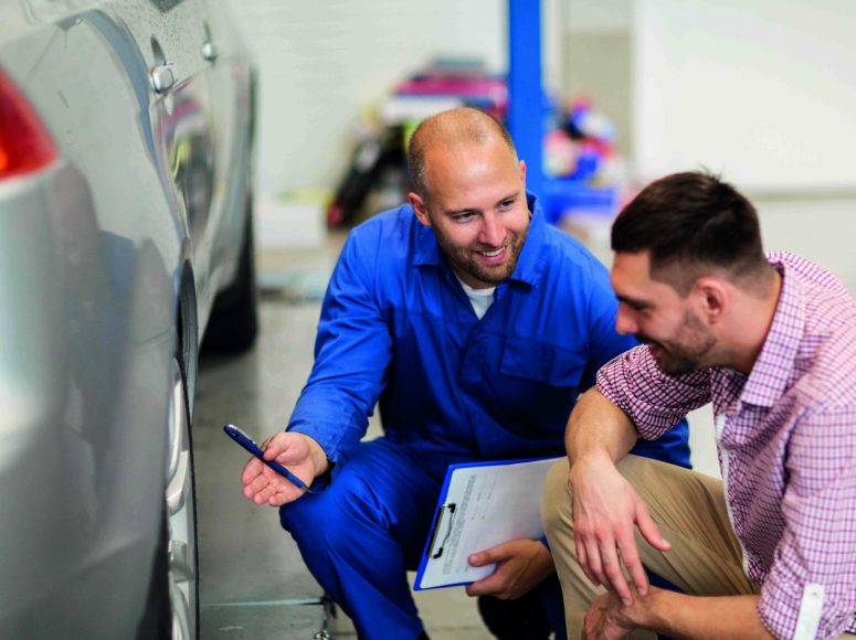 Mechaniker und Kunden besprechen Herstellergarantie beibehalten bei TOP Markenspezialist Autohaus Büschgens . Spezialist für Renault und Dacia
